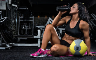 Fit, healthy and lean lady drinking a protein shake.